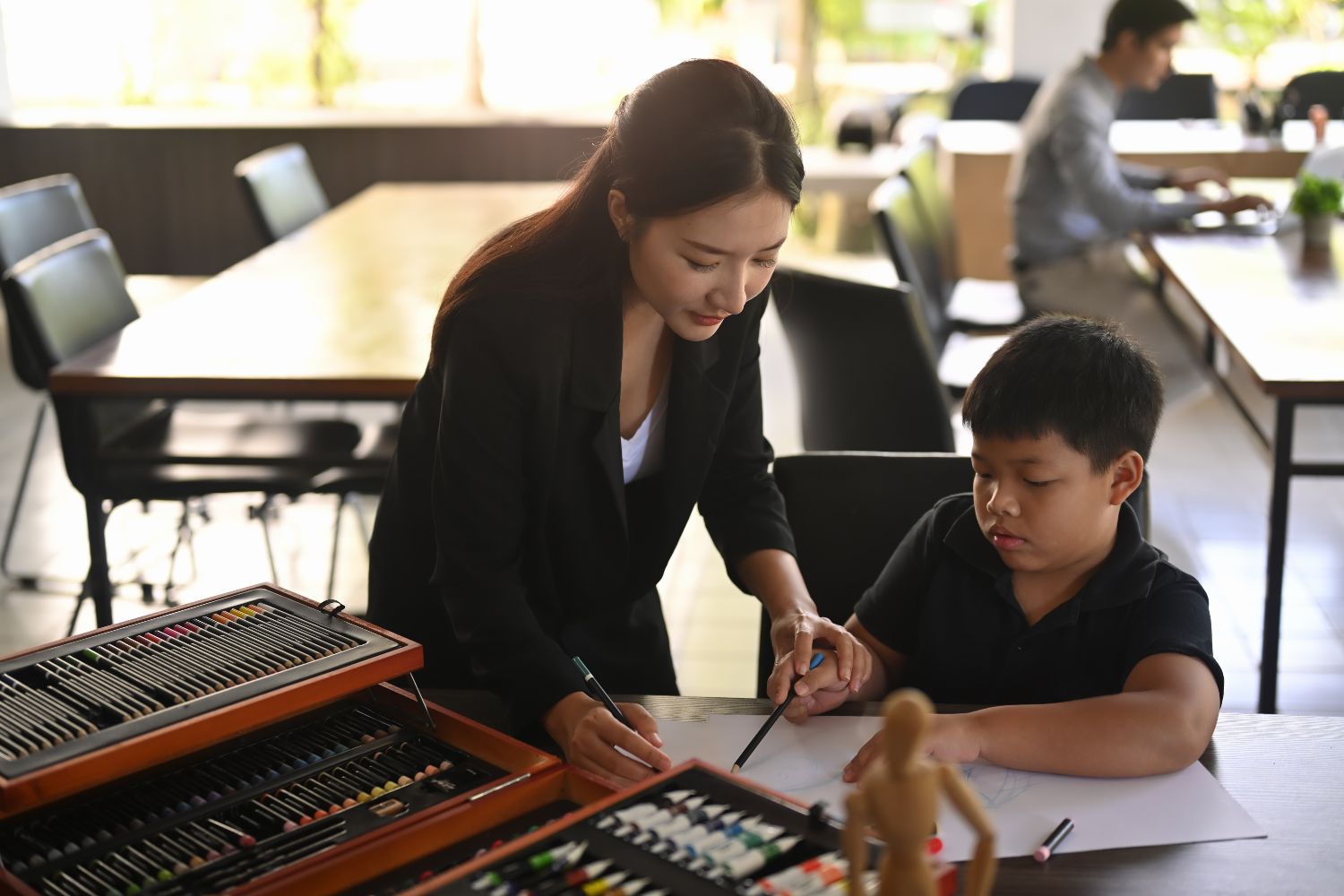 Teacher helping child student with art Teacher helping child student with art